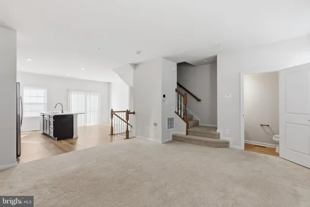 a view of empty room with stairs and mirrors