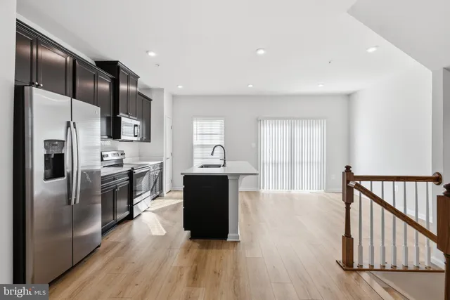 a kitchen with stainless steel appliances granite countertop a refrigerator and a stove top oven