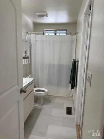 a bathroom with a toilet and a shower