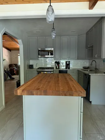 a kitchen with stainless steel appliances granite countertop a sink a stove and a refrigerator