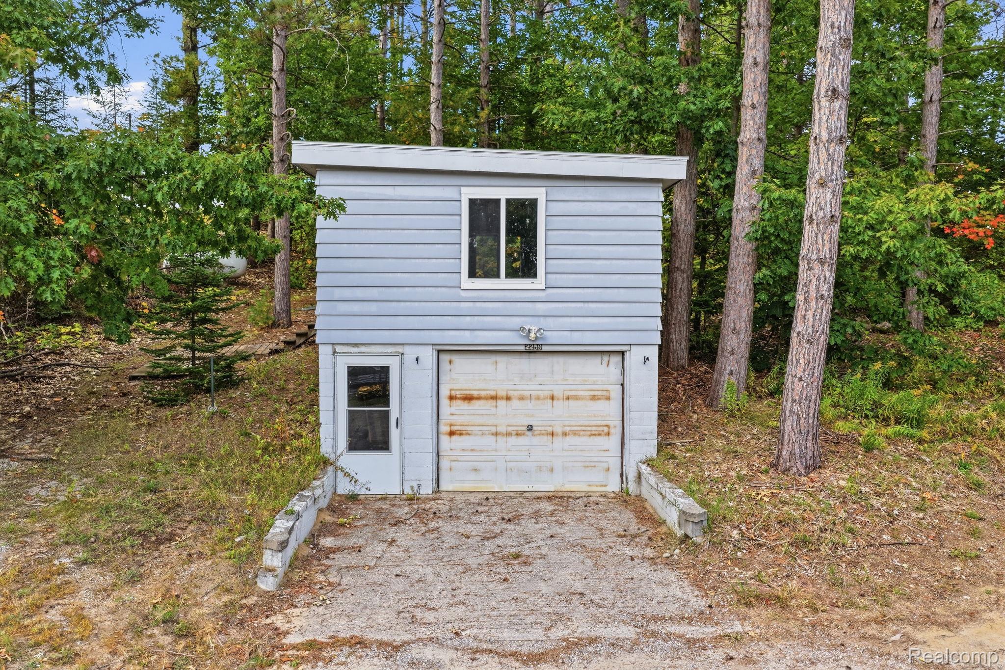 2259 Kassuba Road Gaylord, MI 49735 - Photo 37 of 46 Detached structure featuring horizontal siding, a single window, an entry door, and a garage door