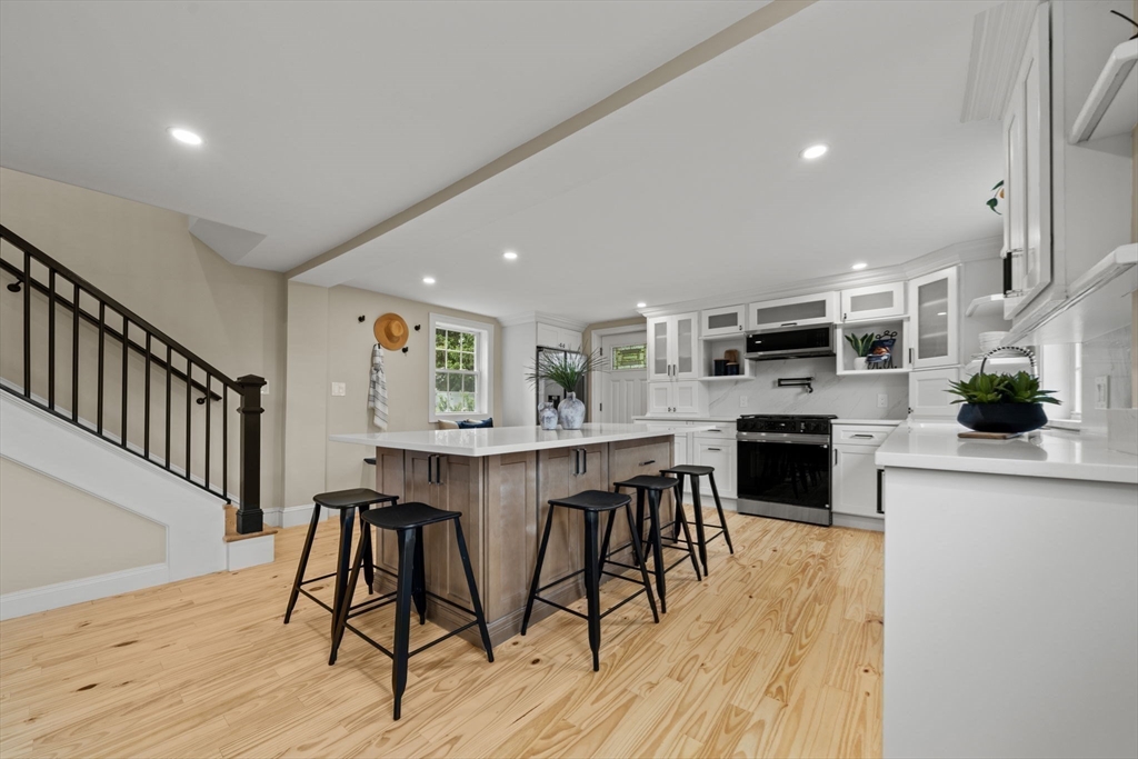 162 High Street, Unit B Danvers, MA 01923 - Photo 9 of 32 a kitchen with stainless steel appliances a dining table chairs stove refrigerator and cabinets