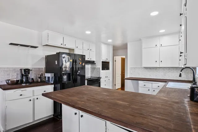a kitchen with stainless steel appliances granite countertop a sink refrigerator and cabinets