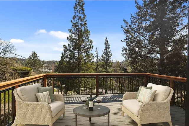 a balcony with wooden floor and outdoor seating