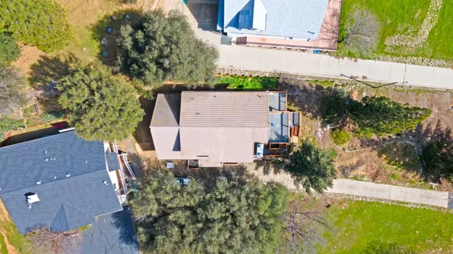 an aerial view of a house with a yard and a large tree