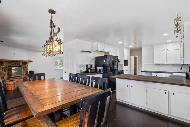 a kitchen with stainless steel appliances a table chairs and white cabinets
