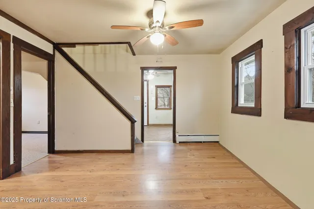 a dining room with wooden floor and furniture