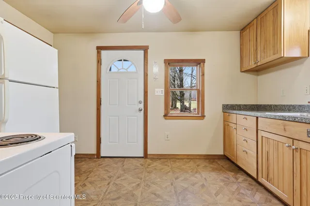 a kitchen with granite countertop a stove a sink and a refrigerator