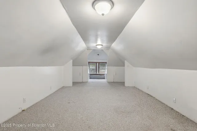 a large bed sitting in a bedroom next to a lamp with potted plant