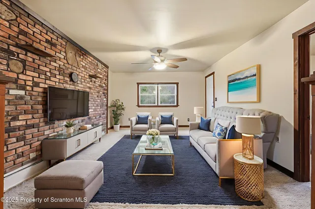 a living room with furniture and a ceiling fan
