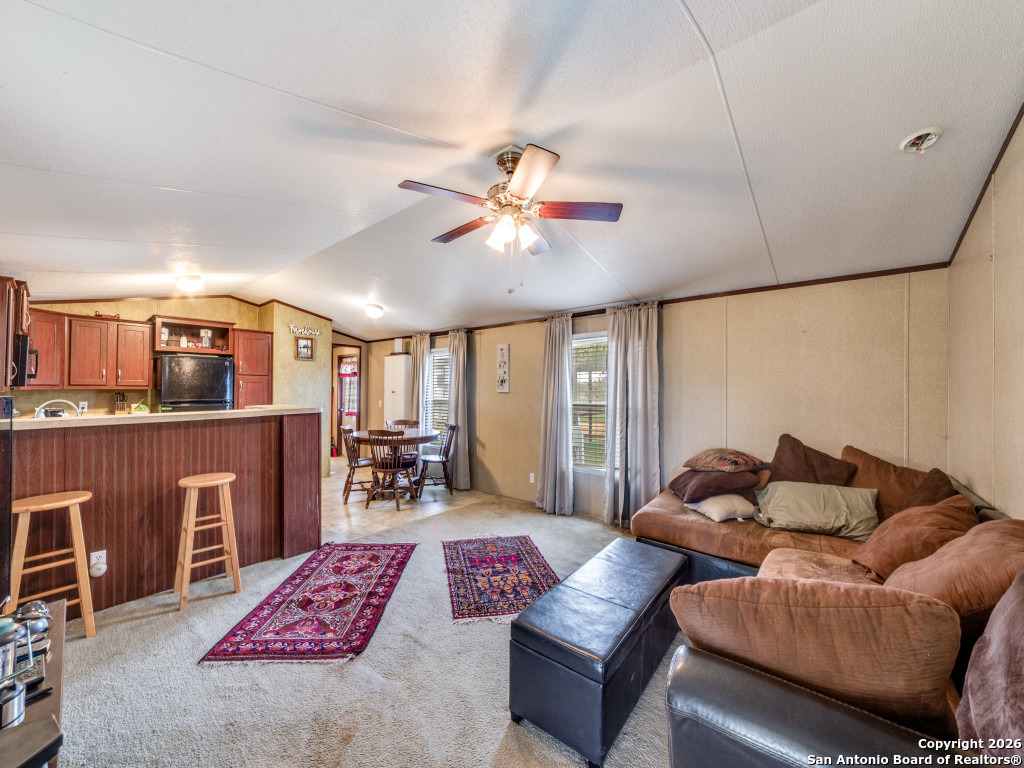 6472 Bluntzer Road Jourdanton, TX 78026 - Photo 31 of 45 a living room with furniture a dining table and a fireplace