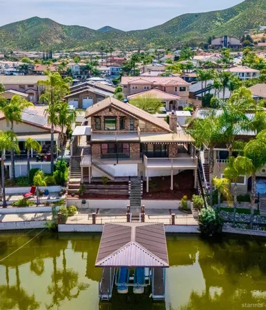 a view of a swimming pool with lounge chairs in front of house