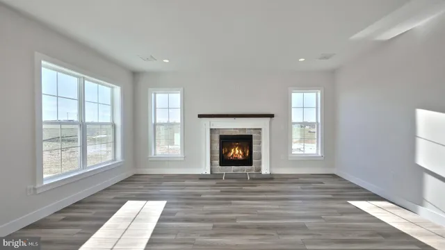 a view of an empty room with a window and fire place