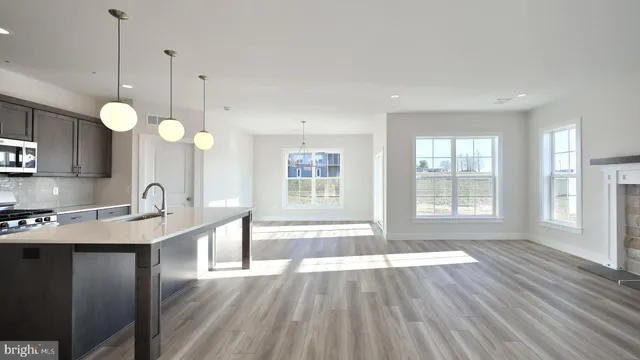 a view of a hallway with wooden floor and a bathroom