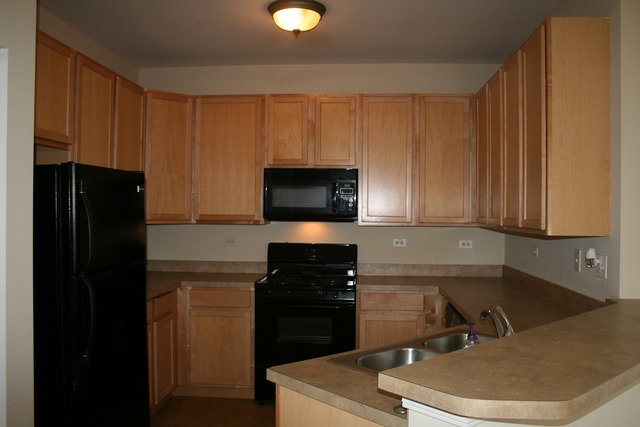 287 Springbrook Trail South Oswego, IL 60543 - Photo 3 of 14 a kitchen with a sink a stove and refrigerator
