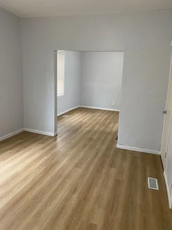 a view of a room with wooden floor and a window