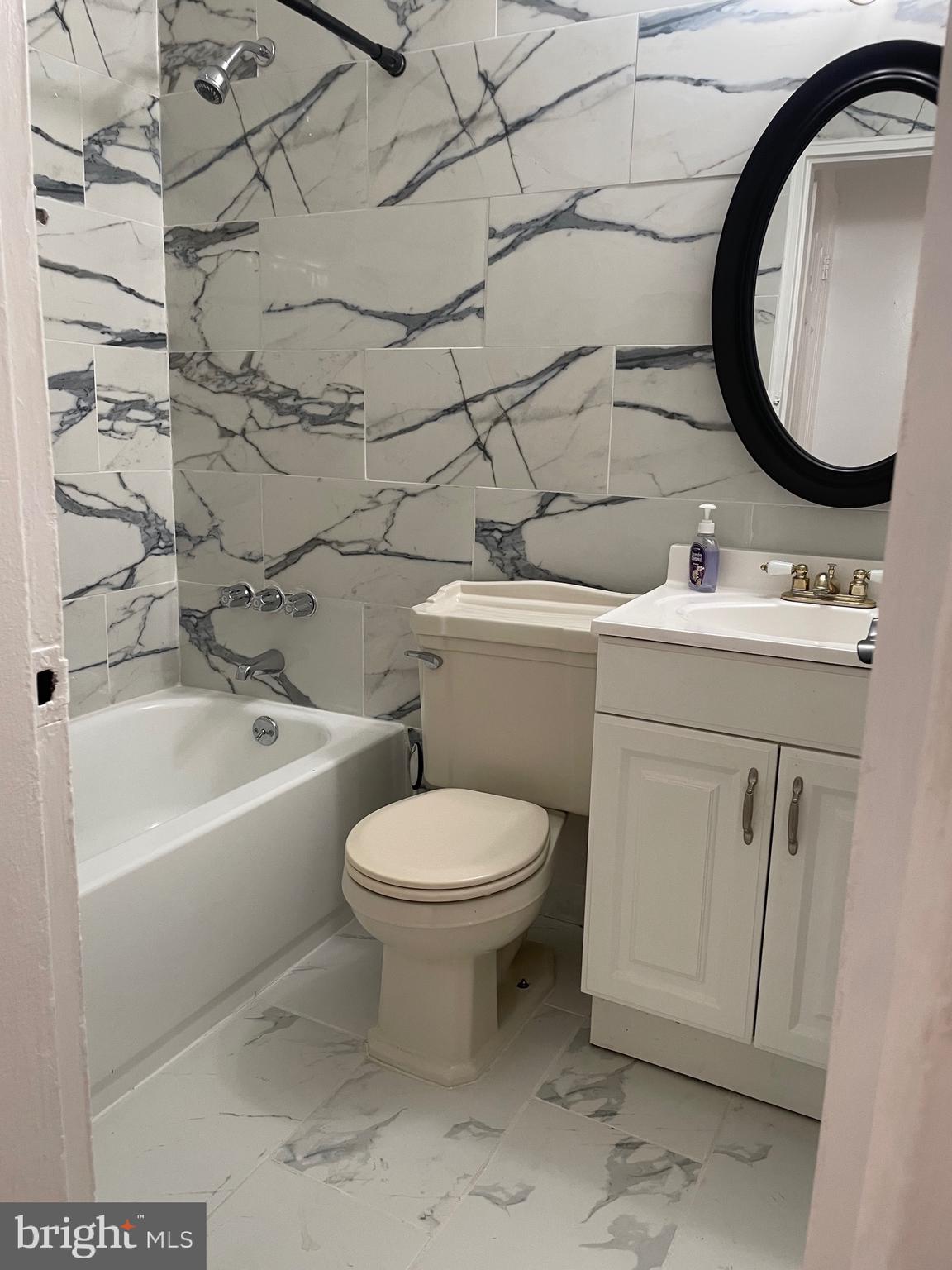 2206 15th Street Northeast Washington, DC 20018 - Photo 6 of 11 a bathroom with a toilet sink vanity tub and mirror