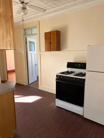 a view of kitchen with sink and refrigerator