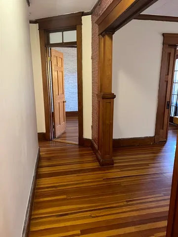 a view of a hallway with wooden floor and staircase