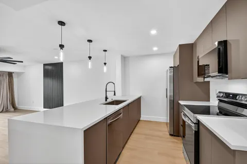 a kitchen with stainless steel appliances a sink stove and refrigerator