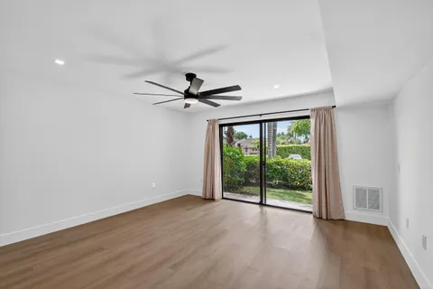 a view of a big room with wooden floor fan and windows
