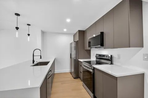a kitchen with stainless steel appliances a stove sink and microwave