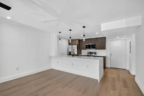 a kitchen with stainless steel appliances a stove top oven a sink and a refrigerator