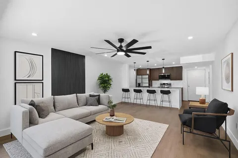a living room with furniture and a view of kitchen