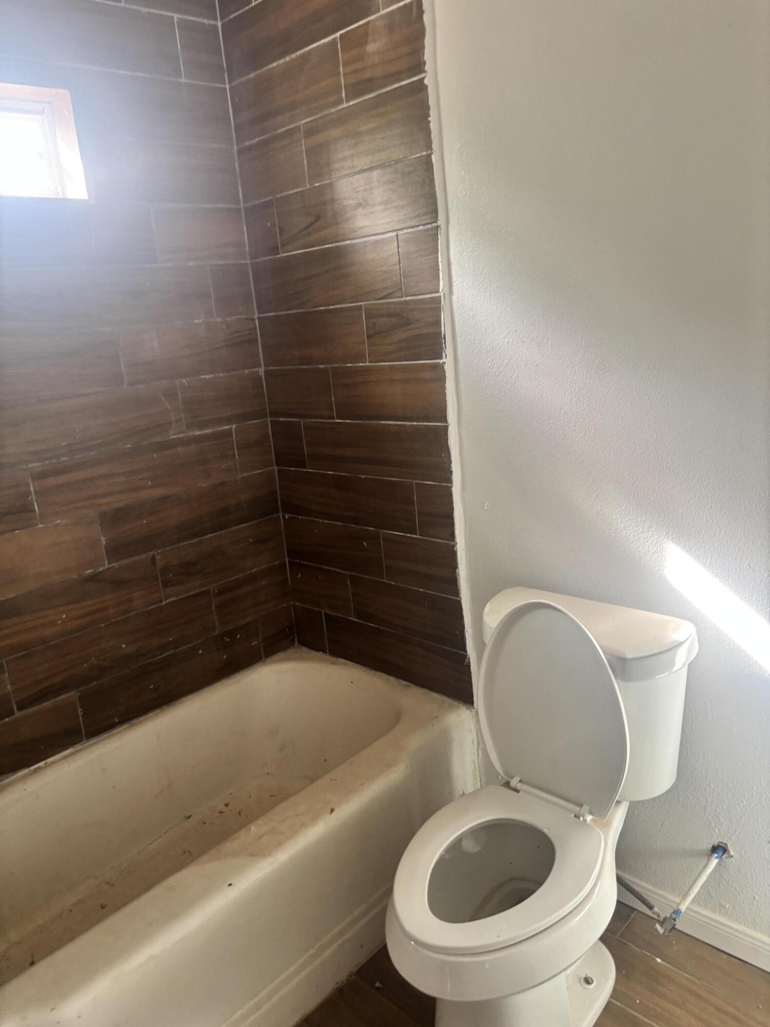 312 East 34th Street Lubbock, TX 79404 - Photo 14 of 25 a bathroom with a toilet and a bathtub