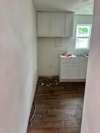 a room with water heater and wooden cabinets
