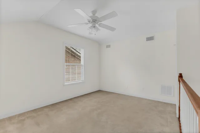an empty room with a window and a fan