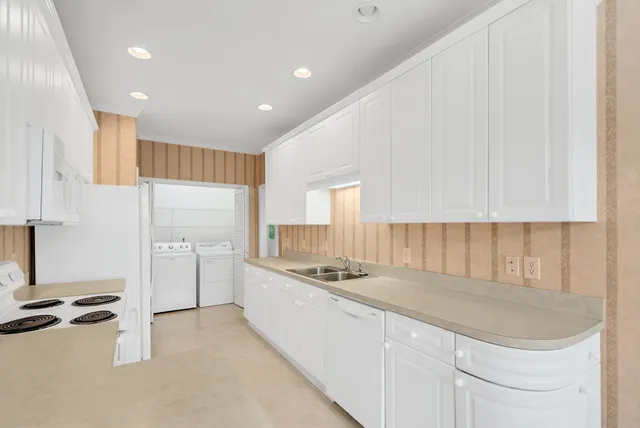 a kitchen with stainless steel appliances granite countertop a sink refrigerator and cabinets