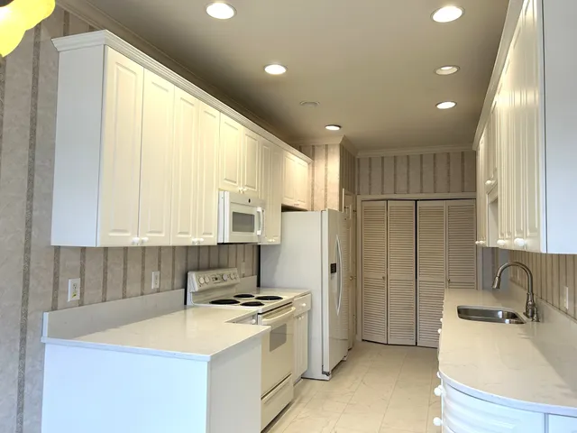a kitchen with stainless steel appliances granite countertop a sink refrigerator and cabinets