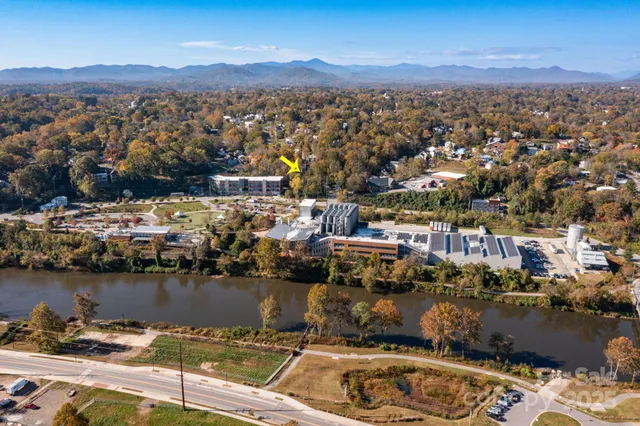 an aerial view of a town with swimming pool and mountains