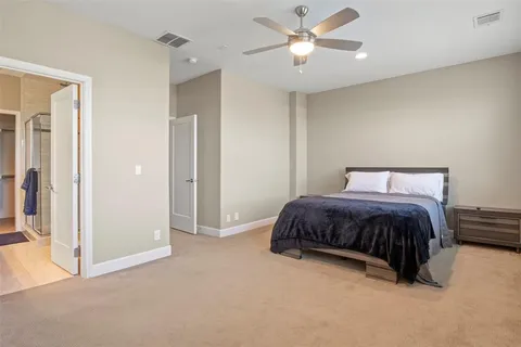 a spacious bedroom with a bed and a chandelier