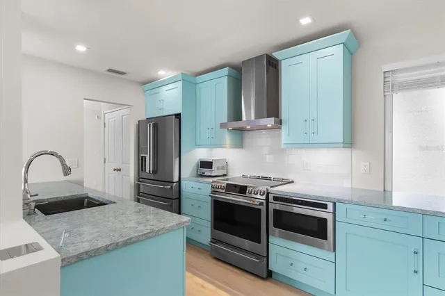 a kitchen with stainless steel appliances granite countertop a sink stove and refrigerator