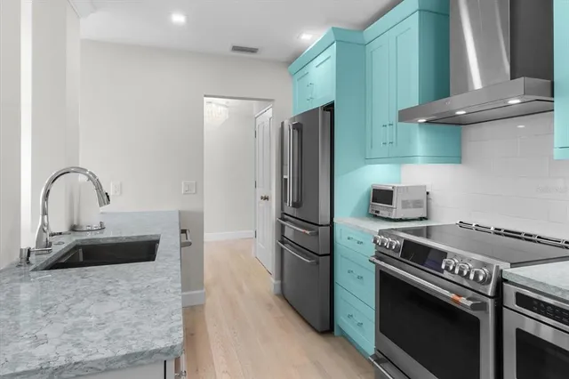 a kitchen with stainless steel appliances granite countertop a sink stove and refrigerator