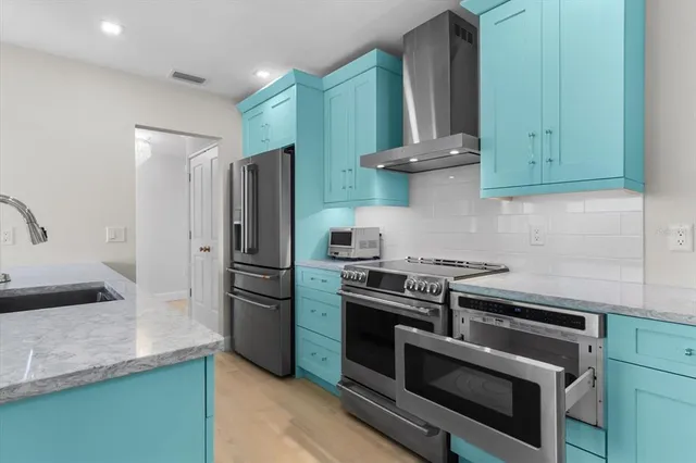 a kitchen with stainless steel appliances granite countertop a stove and a refrigerator