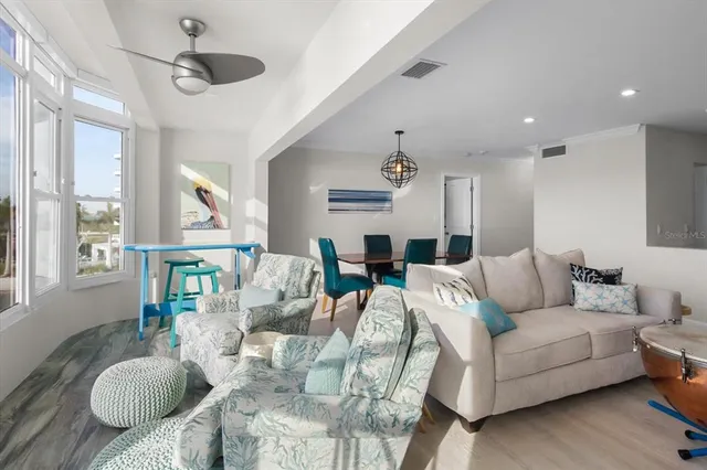 a living room with furniture kitchen view and a large window