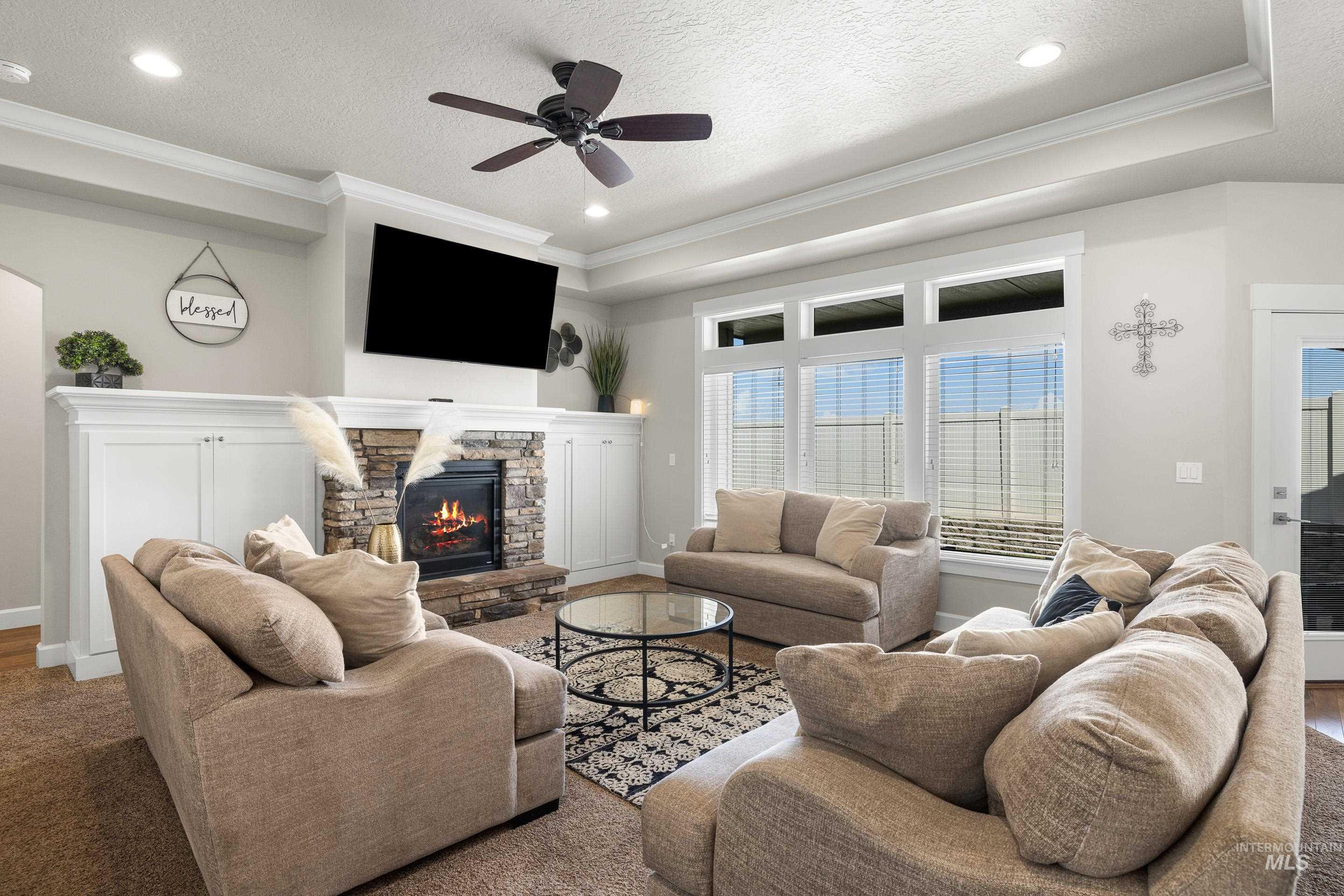 Living area featuring ornamental molding, a ceiling fan, recessed lighting, a fireplace, and a textured ceiling