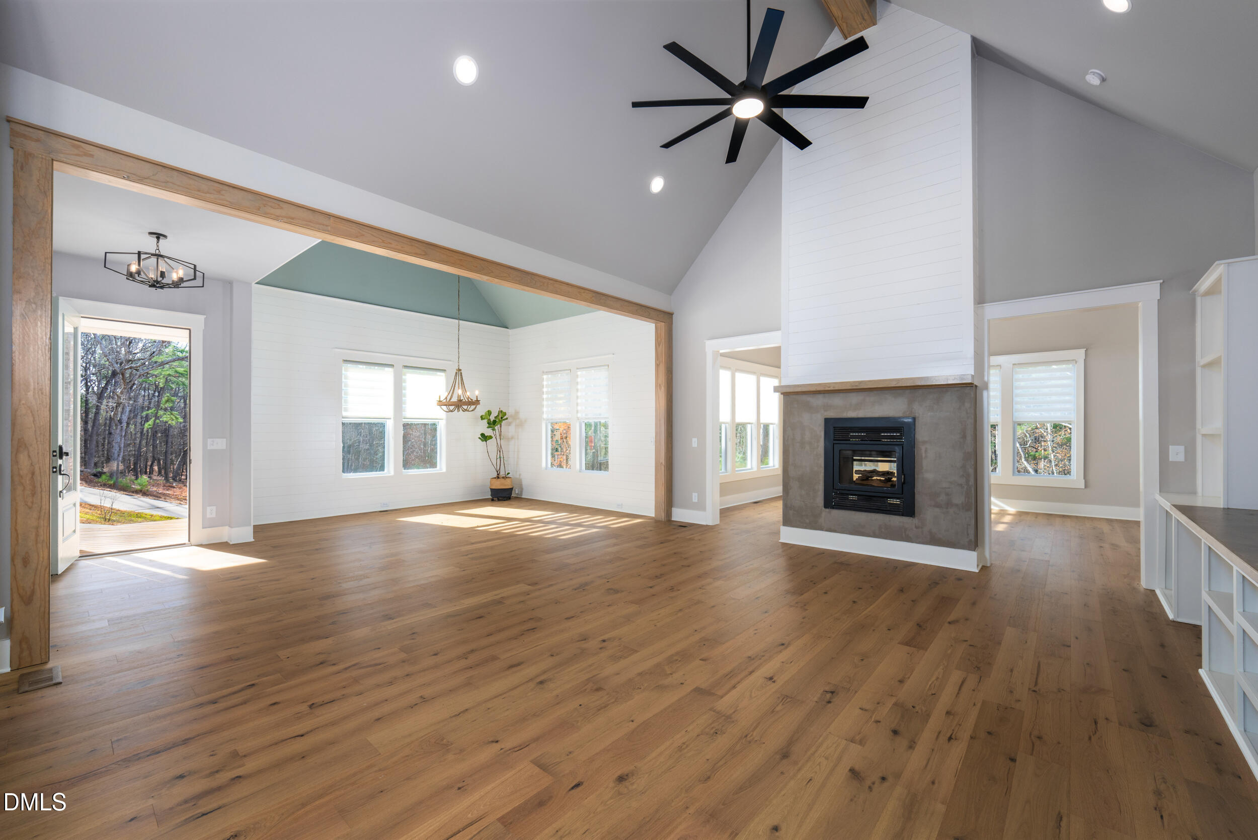 343 Deer Mountain Road Pittsboro, NC 27312 - Photo 18 of 55 an empty room with wooden floor a fireplace and windows