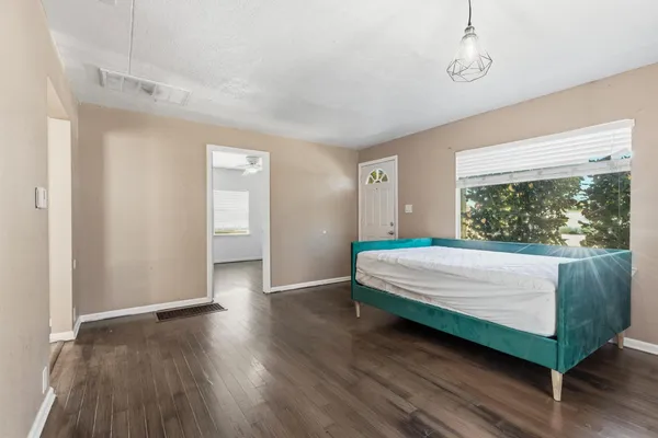 a bed sitting in a spacious bedroom next to a window