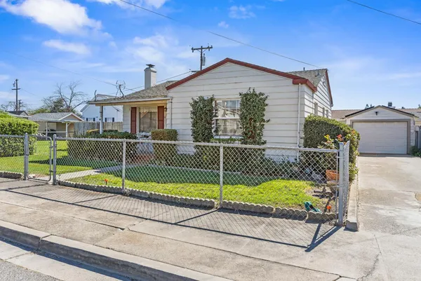 a view of a house with a small yard and deck area