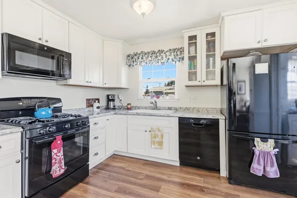 a kitchen with stainless steel appliances granite countertop a stove top oven a refrigerator and a sink