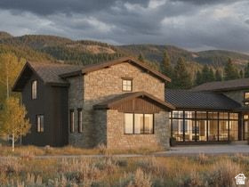 829 River Haven Road, Unit 111 Oakley, UT 84055 - Photo 9 of 12 Stone and wood-sided exterior featuring multiple gabled rooflines, large picture windows, and a metal roof section
