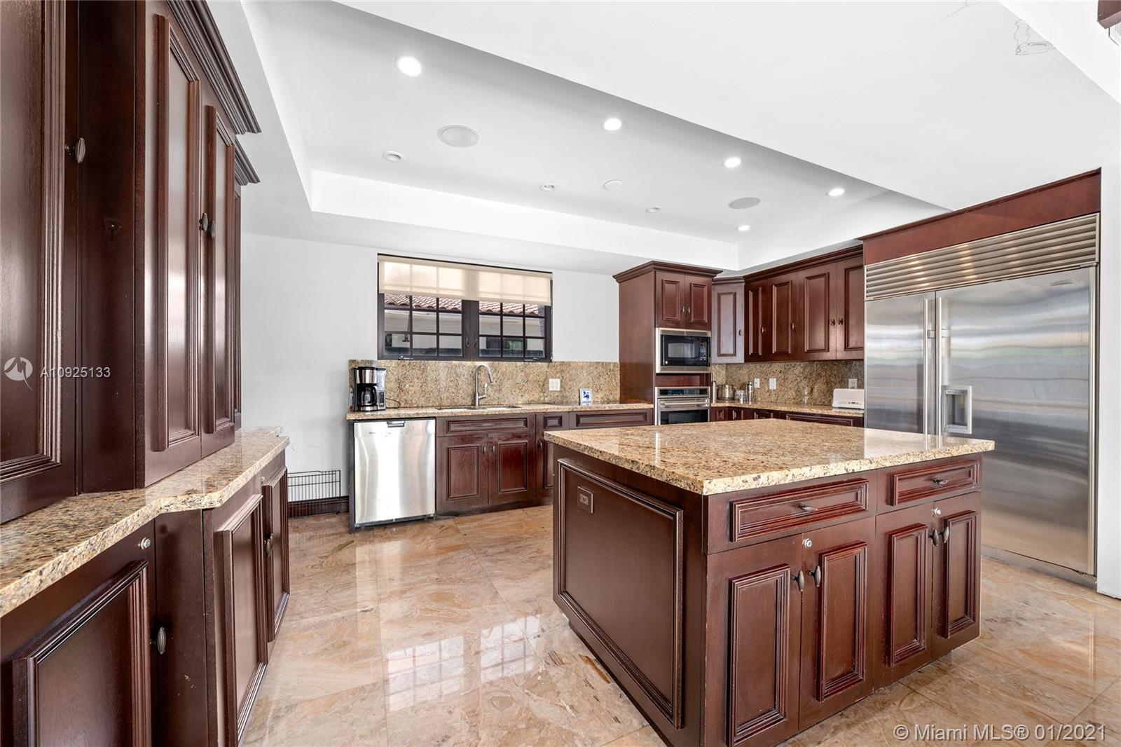 5300 Pine Tree Drive Miami Beach, FL 33140 - Photo 11 of 40 a kitchen with a stove sink and a refrigerator