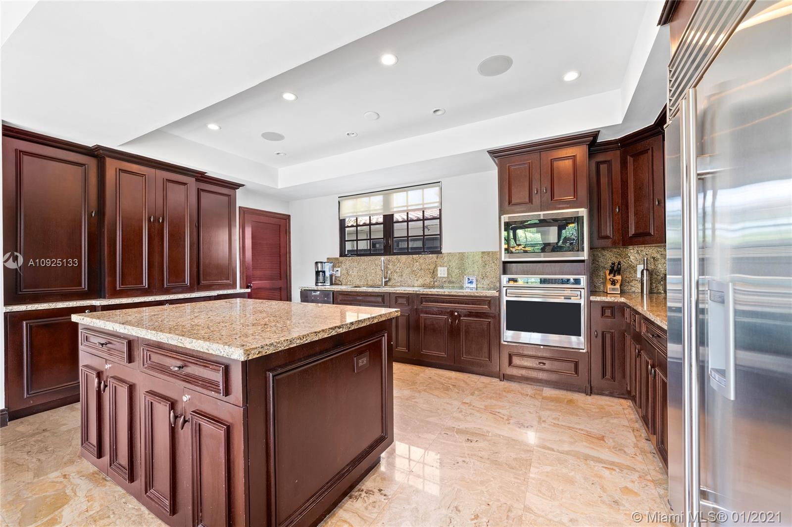 5300 Pine Tree Drive Miami Beach, FL 33140 - Photo 12 of 40 a kitchen with stainless steel appliances granite countertop a stove top oven a sink and a refrigerator