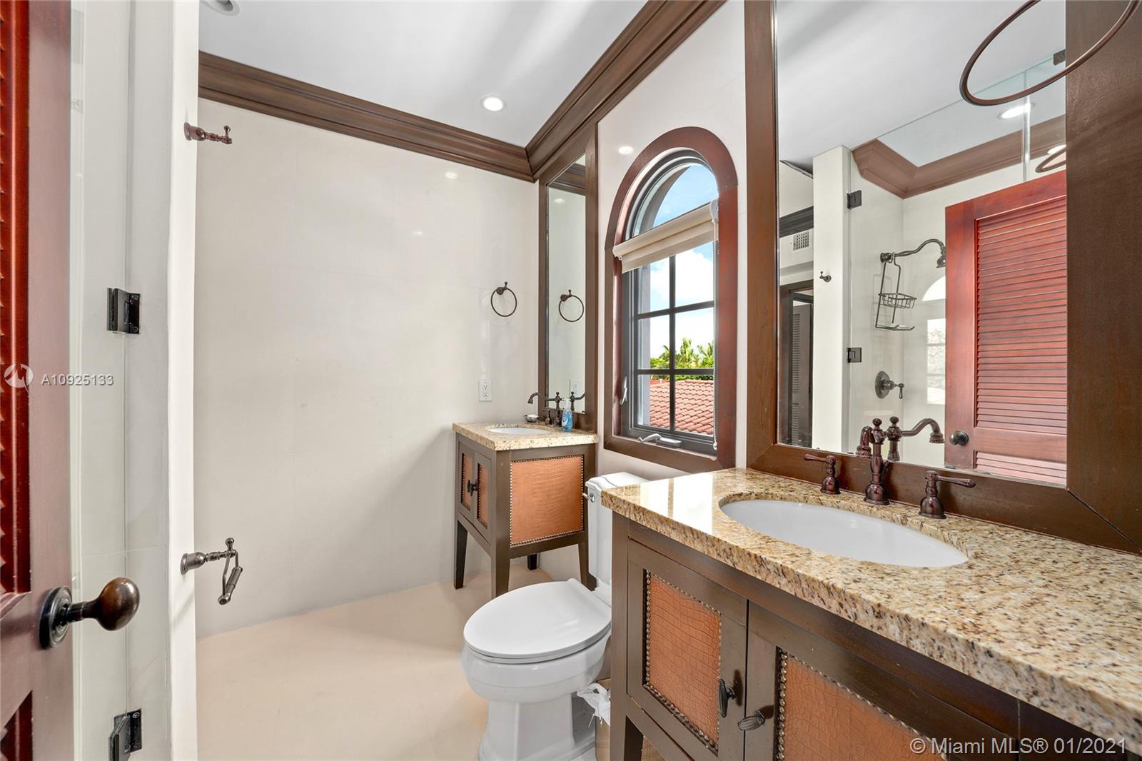 5300 Pine Tree Drive Miami Beach, FL 33140 - Photo 18 of 40 a bathroom with a granite countertop sink a toilet and a mirror