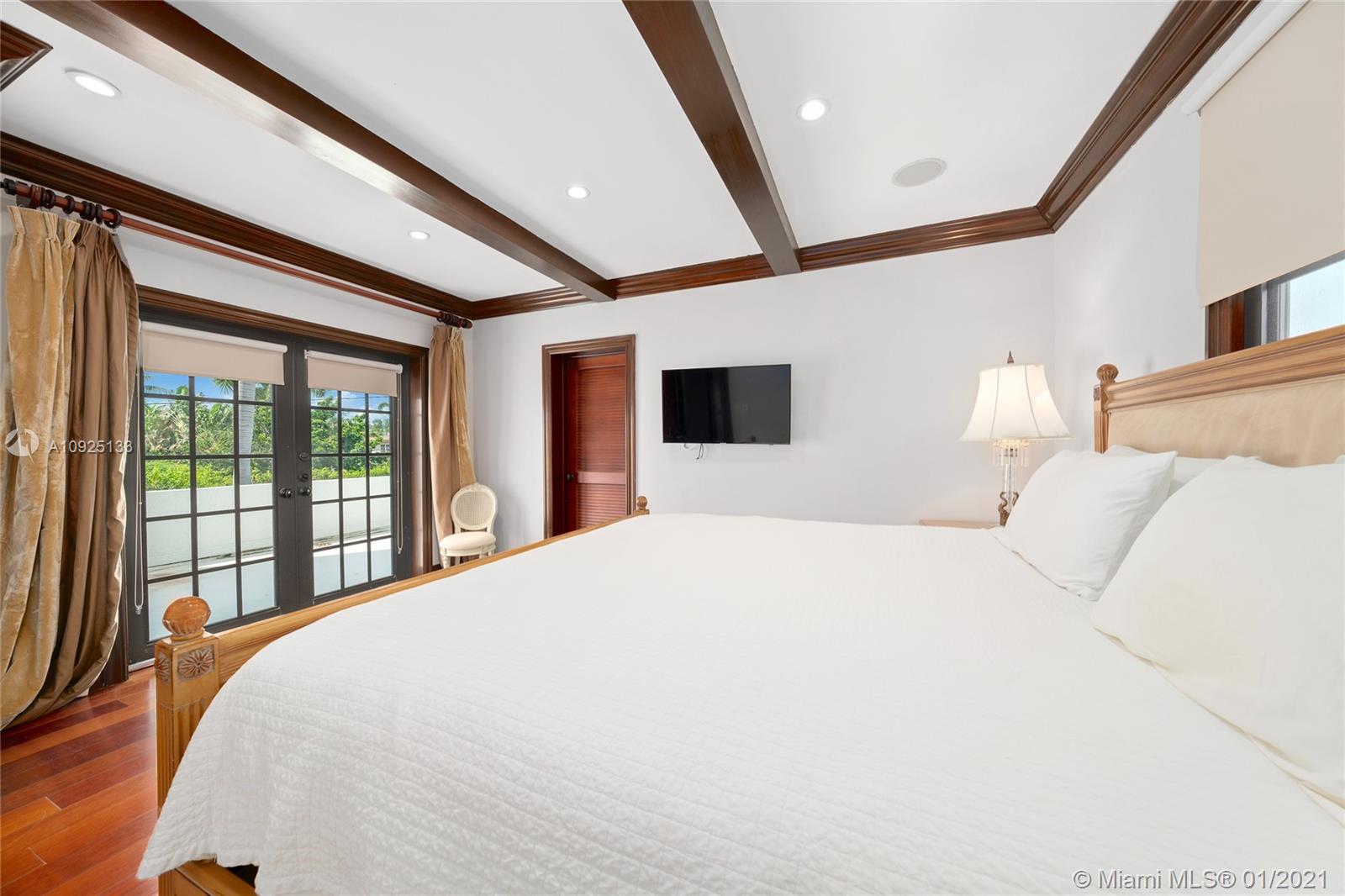 5300 Pine Tree Drive Miami Beach, FL 33140 - Photo 20 of 40 a bedroom with a large bed and a large window