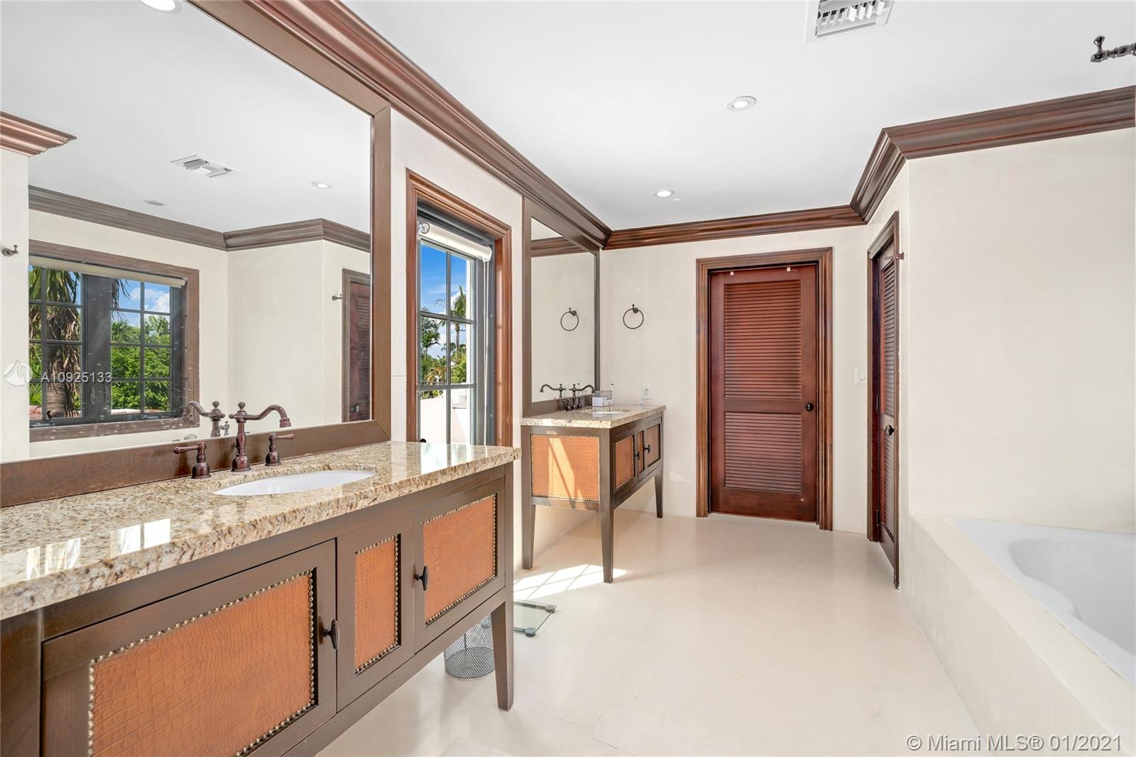 5300 Pine Tree Drive Miami Beach, FL 33140 - Photo 24 of 40 a large bathroom with a granite countertop double vanity sink and a large mirror